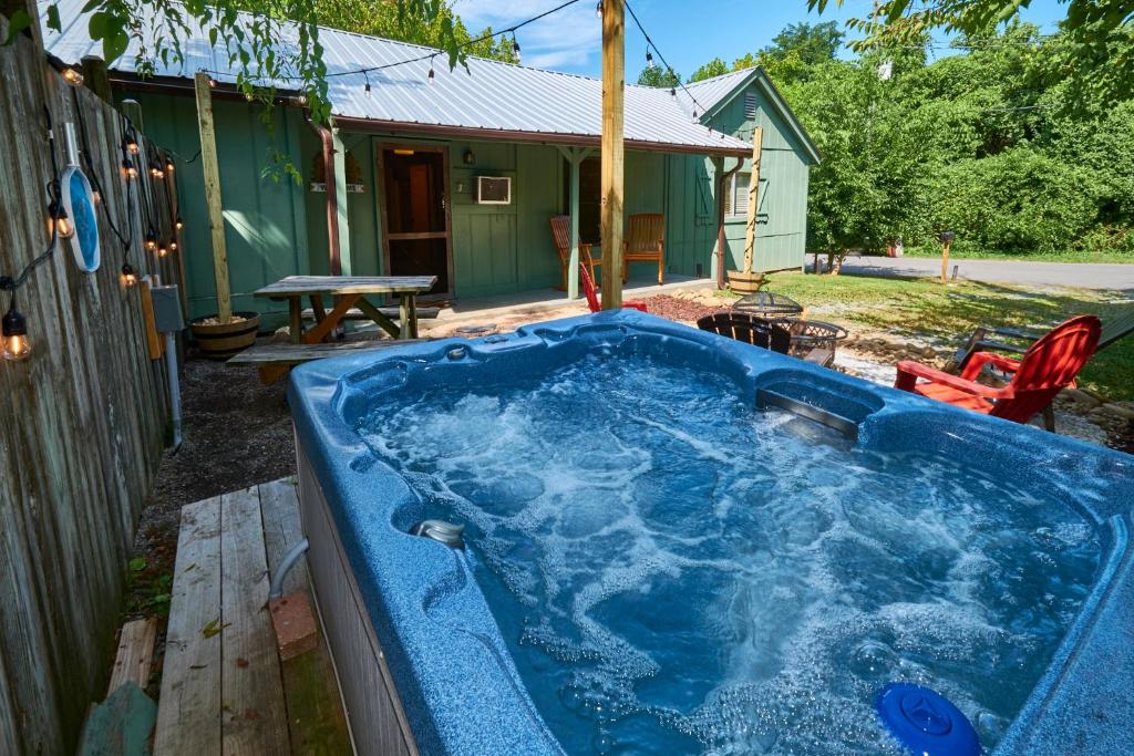 鴿子谷的住宿－Steps from Downtown Pigeon Forge Parkway + Private Hottub and firepit - Wifi - Firefly Bungalows，一个带房子的院子内的蓝色热水浴缸