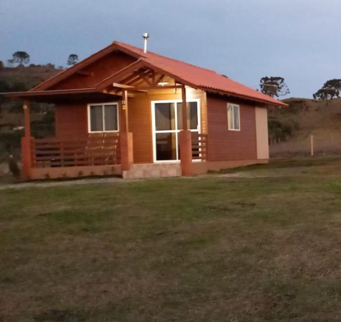 ein kleines Haus mit rotem Dach auf einem Feld in der Unterkunft Cabana Campinho II in Mundo Novo
