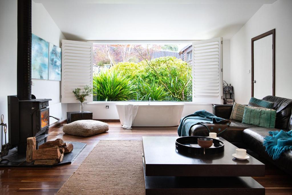 a living room with a couch and a fireplace at Chestnut Daylesford in Daylesford