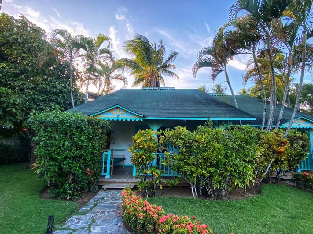 a blue house with palm trees and a garden at Villa 20 in Las Terrenas