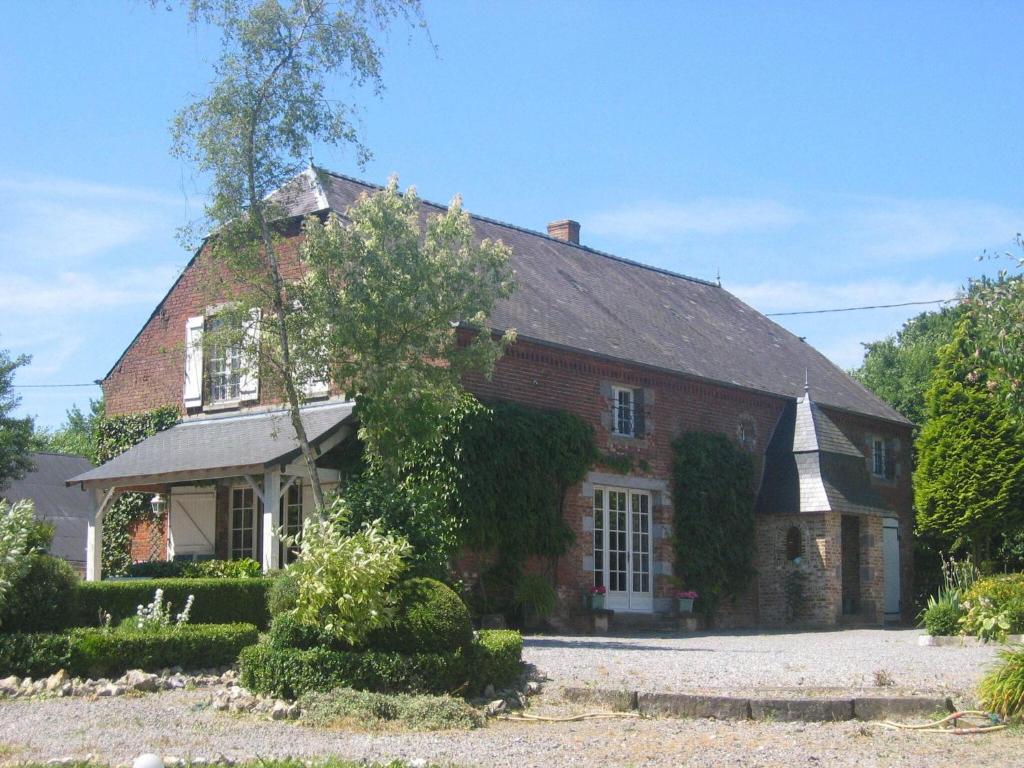 uma grande casa de tijolos com hera a crescer nela em Alluring Cottage in Englancourt with Fenced Garden em Englancourt