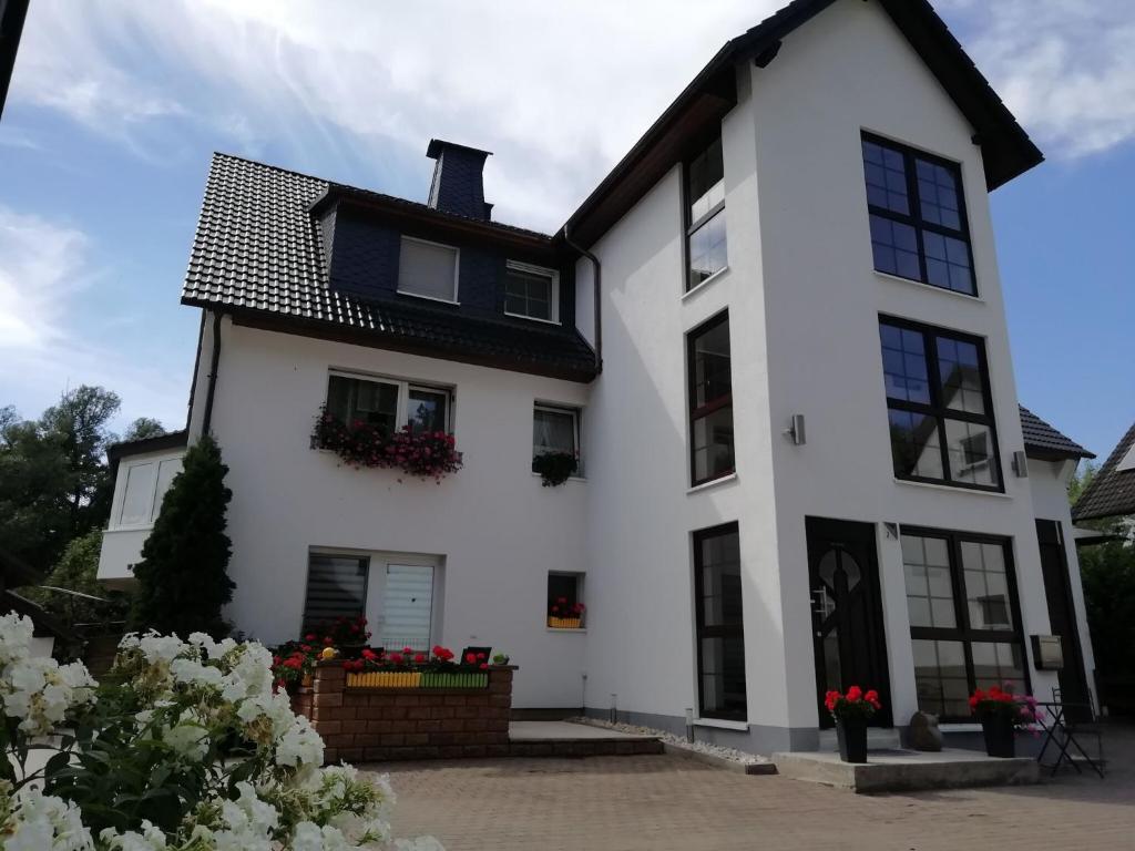 une maison blanche avec un toit noir dans l'établissement Modern holiday home idyllic setting with terrace, à Medebach