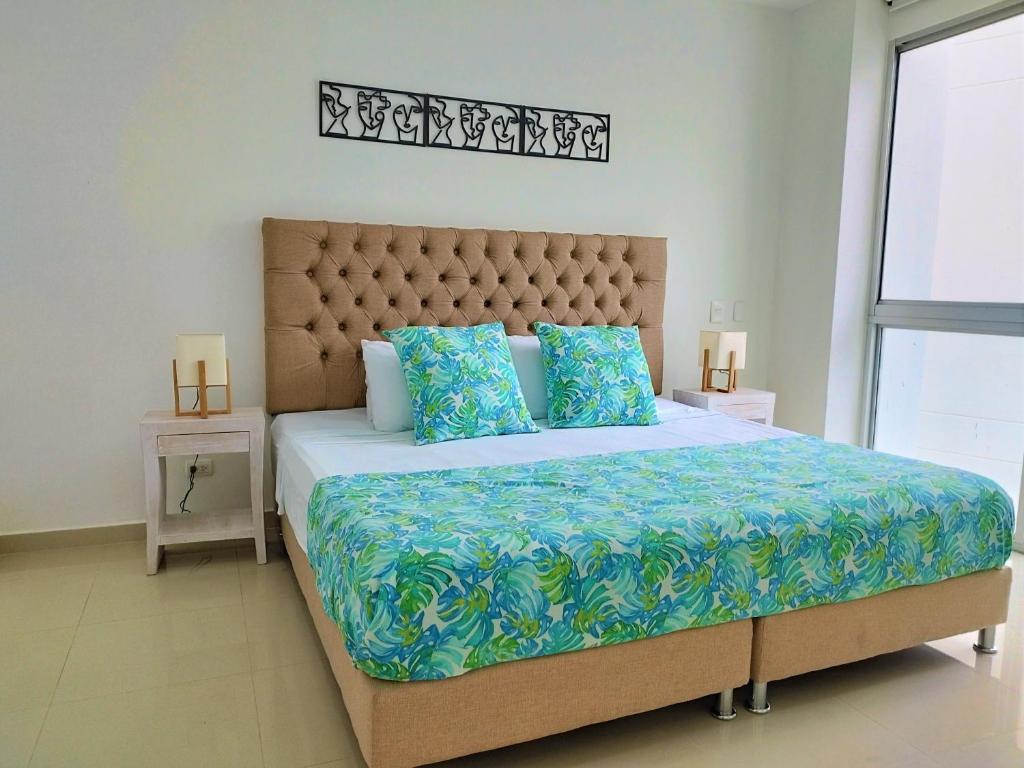 - une chambre avec un grand lit et des oreillers bleus dans l'établissement Morros Epic, à Carthagène des Indes