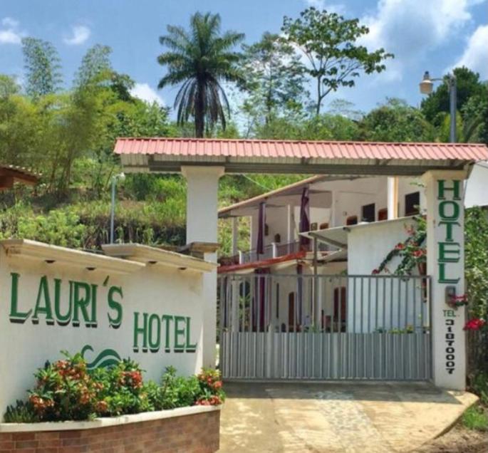 a hotel with a gate in front of a building at Lauris Hotel in Lanquín
