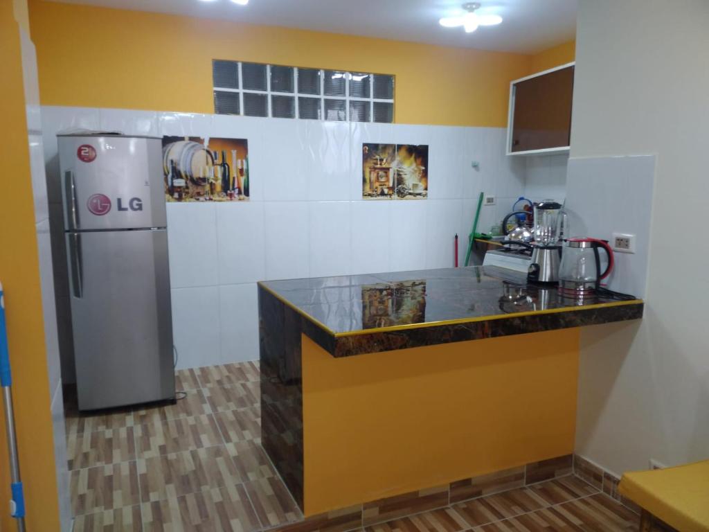 a kitchen with a counter and a refrigerator at ACOGEDOR DEPARTAMENTO in Coroico