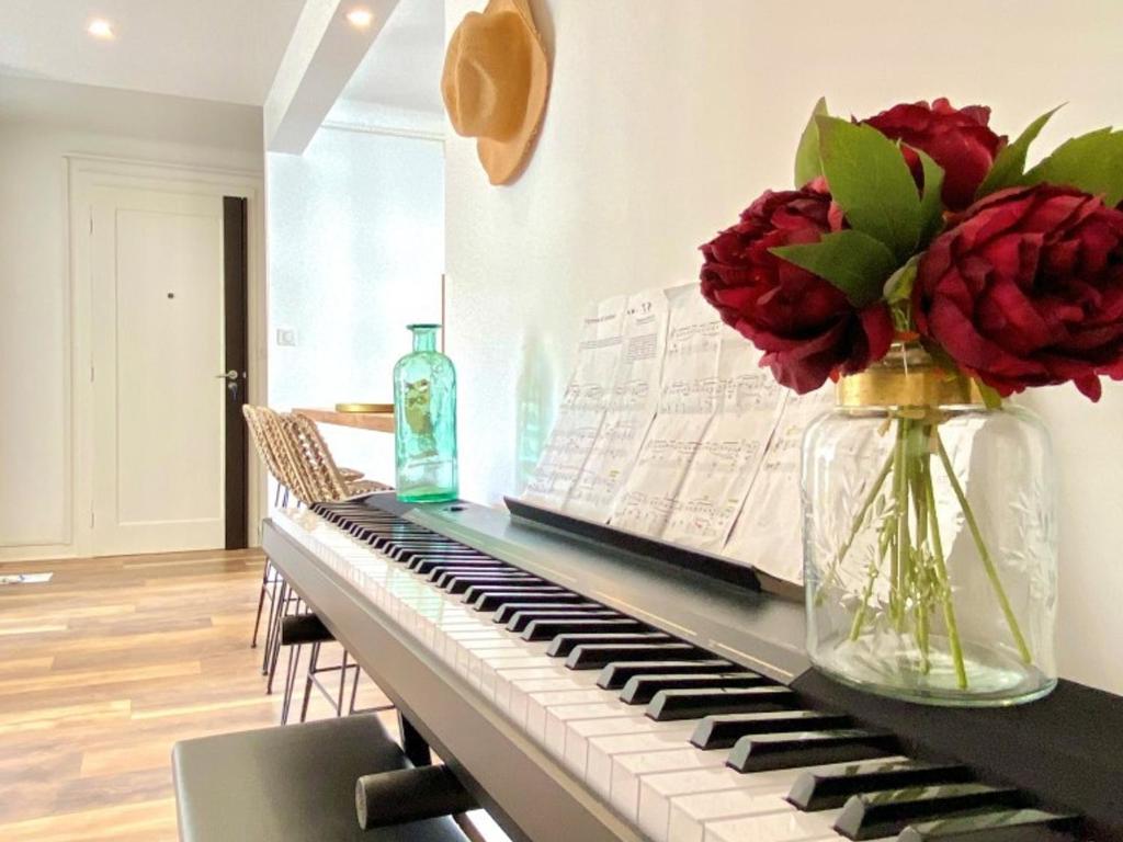 un vase de fleurs assis au-dessus d'un piano dans l'établissement Charmant T3 rénové en centre-ville d'Annecy avec balcon, ascenseur et parking privé - FR-1-432-83, à Annecy