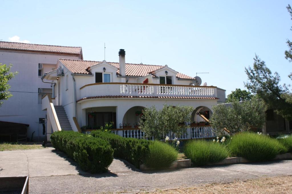 a large white house with a balcony on top of it at Apartments with a parking space Pirovac, Sibenik - 6246 in Pirovac