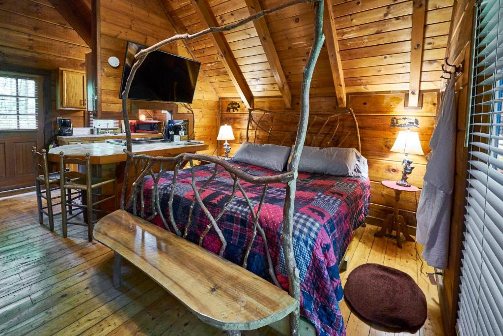 een slaapkamer met een bed in een houten hut bij Wild Columbine - Gatlinburg Area Hottub Romantic Cabin in Sevierville