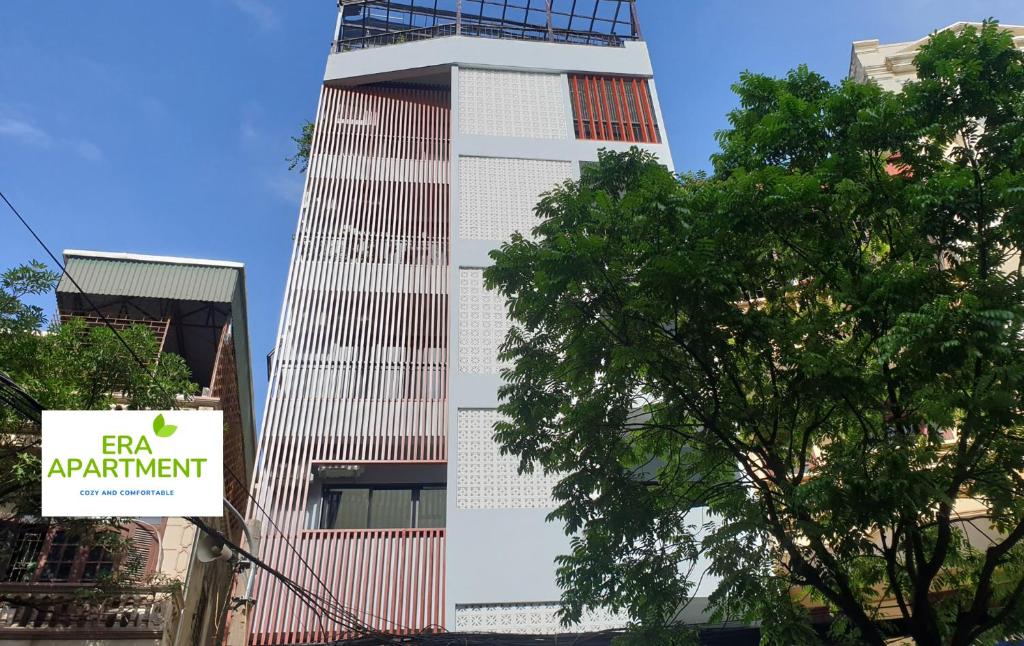 un edificio alto con un cartel delante en Era Apartment Xuân Thuỷ, en Hanói