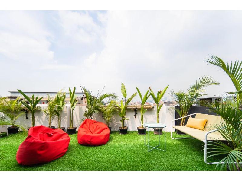 zwei rote Stühle und ein Tisch auf einem Rasen mit Palmen in der Unterkunft Cove T63 in Jakarta