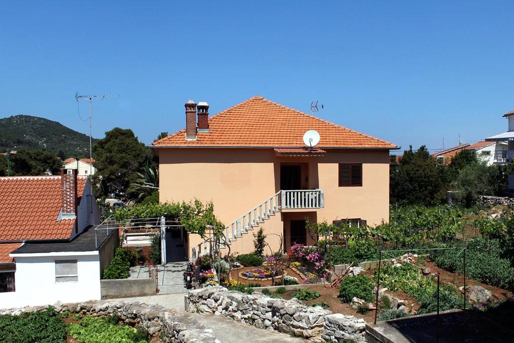 a house with a garden in front of it at Apartments by the sea Veli Iz, Iz - 6255 in Veli Iž