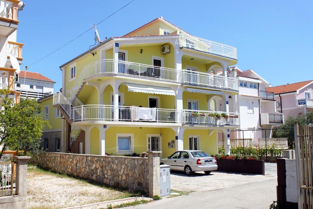 ein gelbes Haus mit einem davor geparkt in der Unterkunft Apartments with a parking space Vodice - 6233 in Vodice