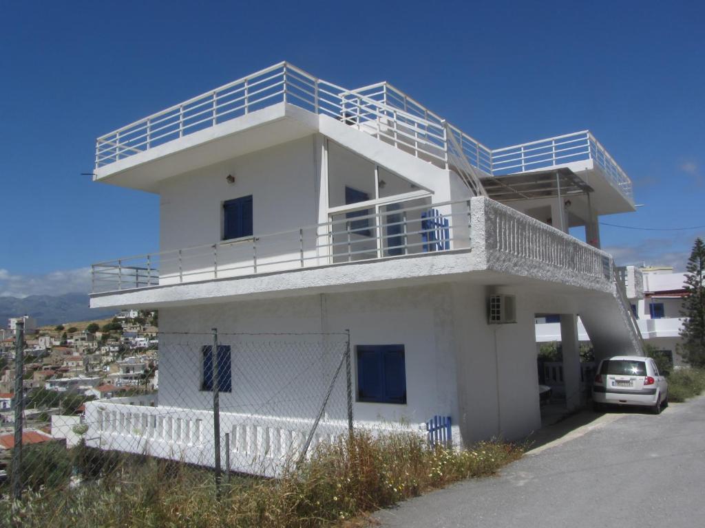 a white house with a balcony on top of it at PanoramaKamil in Kamilari