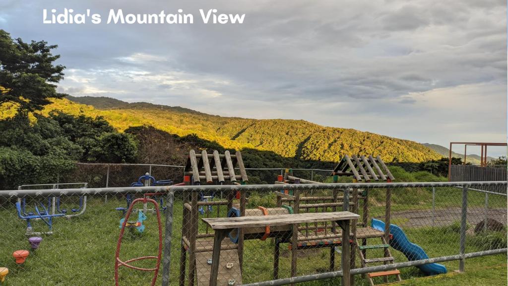 a playground with three play equipment in the grass at Lidia's Mountain View Vacation Homes in Monteverde Costa Rica