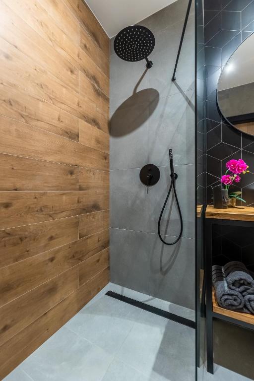 a bathroom with a shower with wooden wall at Loftowe Love in Kołobrzeg