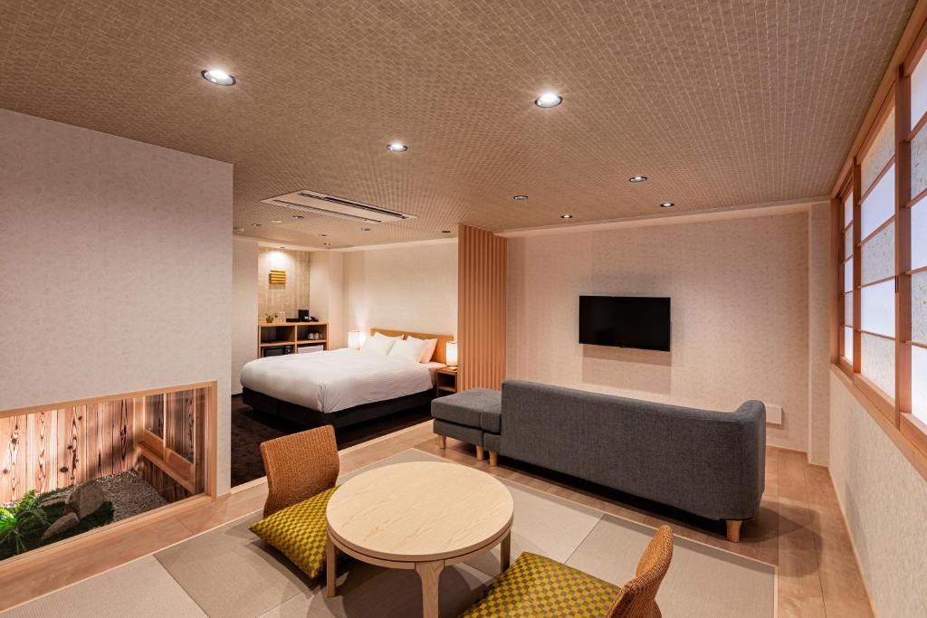 京都市にあるRinn Gion Kenninji Villa（鈴 祇園建仁寺別邸）のベッドとテーブルが備わるホテルルームです。