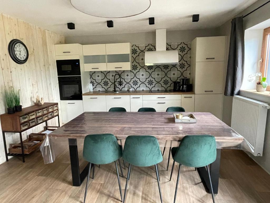 een keuken met een houten tafel en groene stoelen bij Lovely Home 1, with private terrace and Whirlpool,4-6 pers in Bullange