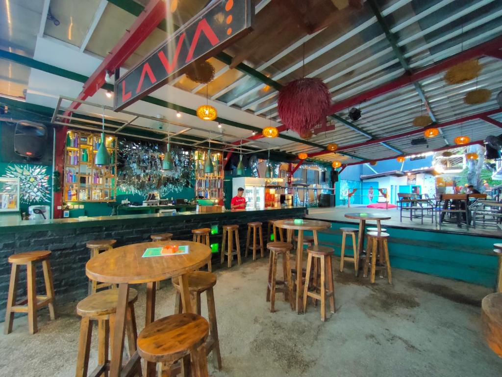 a bar with wooden tables and stools in a restaurant at Gili Beach Bum Hotel in Gili Trawangan