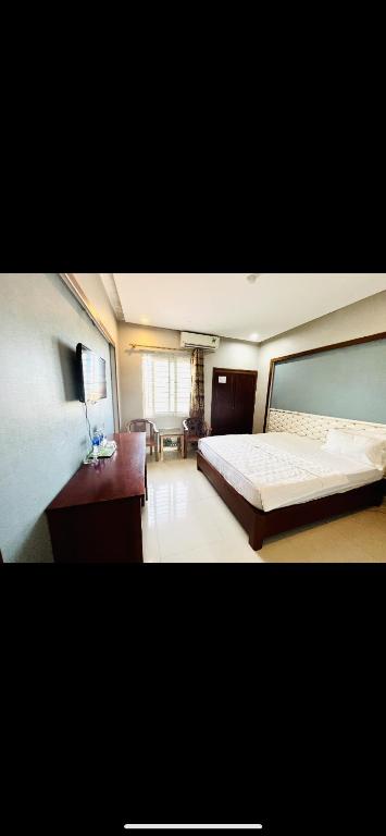 a bedroom with a large bed and a living room at Hoang Ngan 1 Hotel - TP. Vinh in Vinh