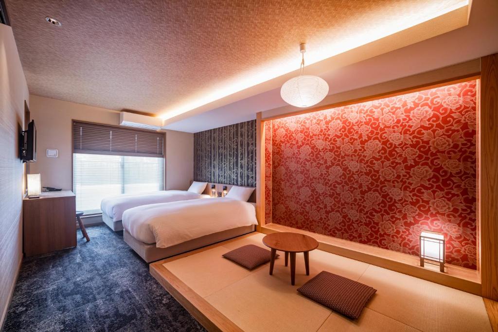 a bedroom with two beds and a red wall at Rinn Gion Kenninji in Kyoto