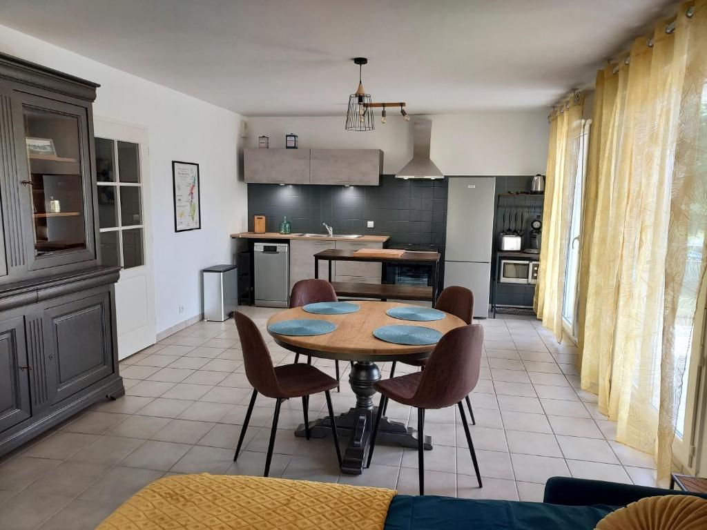 een keuken en eetkamer met een tafel en stoelen bij Georges, un appartement au look chic rustique in Saint-Georges-sur-Baulche