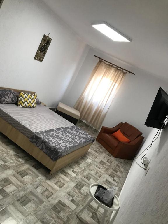 ein Schlafzimmer mit einem Bett und einem Stuhl in der Unterkunft CASA DENIZ in 2 Mai