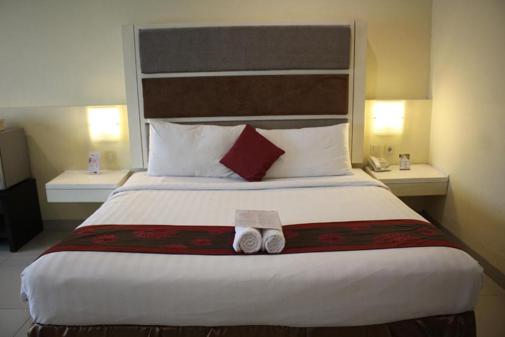 a bedroom with a large bed with two towels on it at President Executive Club in Cikarang