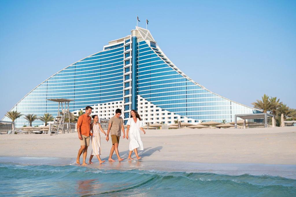 people standing on top of a beach at Jumeirah Beach Hotel in Dubai