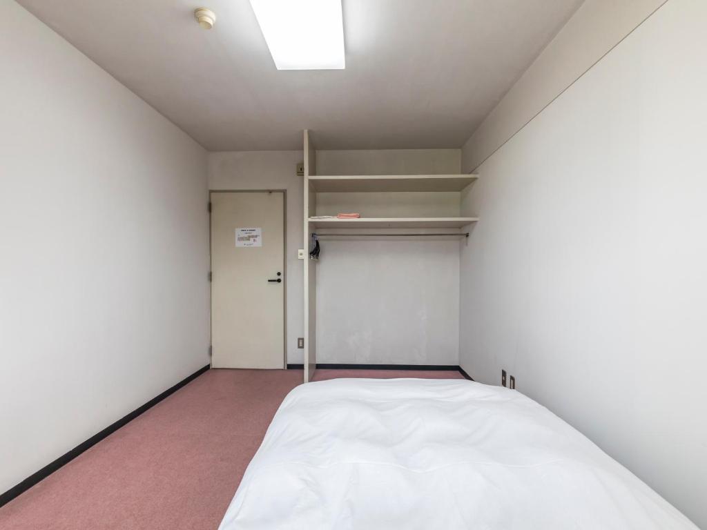 Postel nebo postele na pokoji v ubytování Tabist Raika Hiroshima Miyoshi