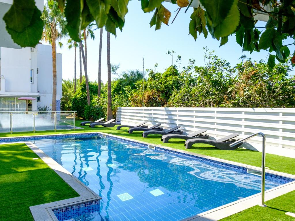 uma piscina com espreguiçadeiras num quintal em Rio Gardens Aparthotel em Agia Napa