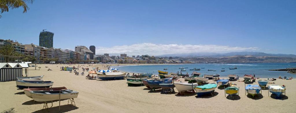 a group of boats sitting on the sand on a beach at Miami Santa Catalina in Las Palmas de Gran Canaria