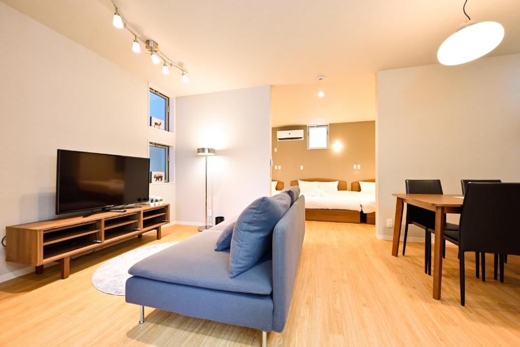a living room with a tv and a blue couch at Hotel AZUMA SEE in Tokyo
