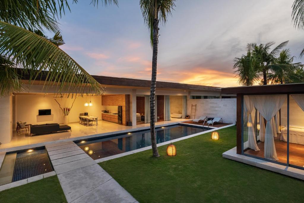 a villa with a swimming pool and a living room at One Eleven in Seminyak