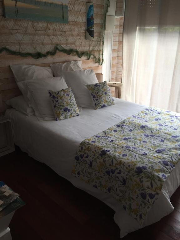 - une chambre avec un grand lit et des oreillers dans l'établissement LA MAISON DES HIPPOCAMPES, à La Teste-de-Buch