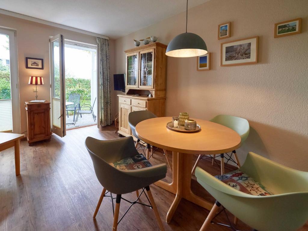 een eetkamer met een tafel en groene stoelen bij Wohnpark Stadt Hamburg - Apt. 41 in Binz