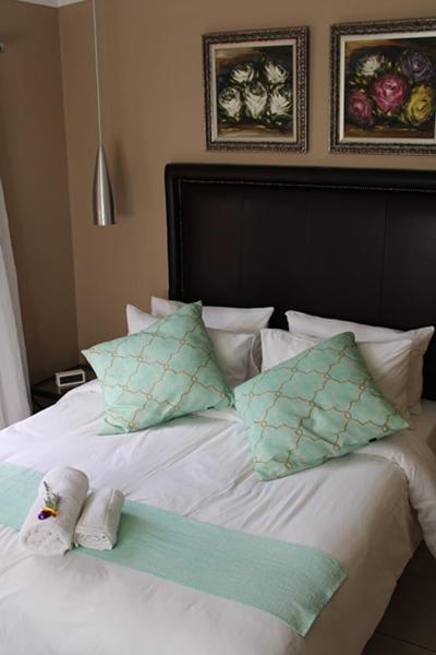 a white bed with pillows and a towel on it at Salveo Self-Catering Accommodation in Kimberley