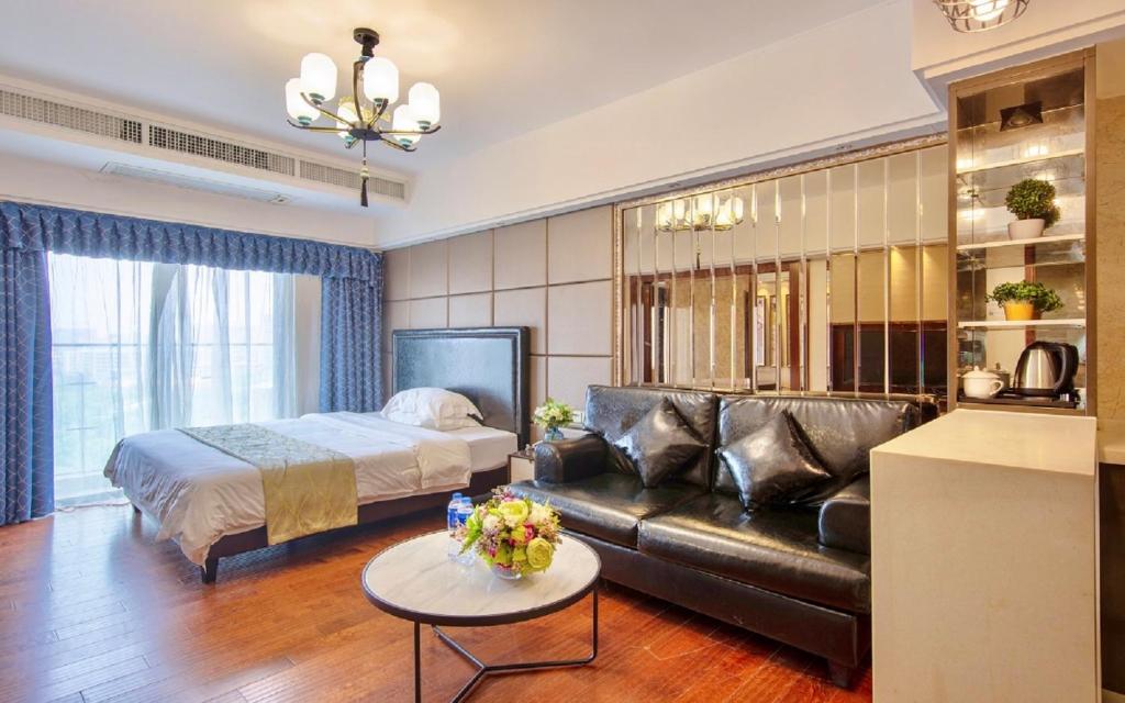 Foshan Yumi Apartment Bodun Branch في فوشان: غرفة معيشة مع سرير وأريكة