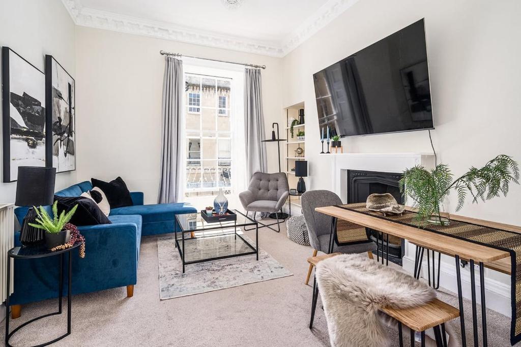 a living room with a blue couch and a tv at BRAND NEW LISTING Beautiful 2 bedroom apartment in Bath