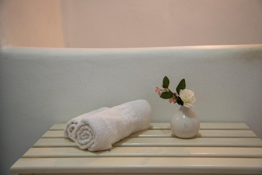 une serviette et un vase avec une fleur sur une table dans l'établissement Villa Foivos, à Agios Romanos