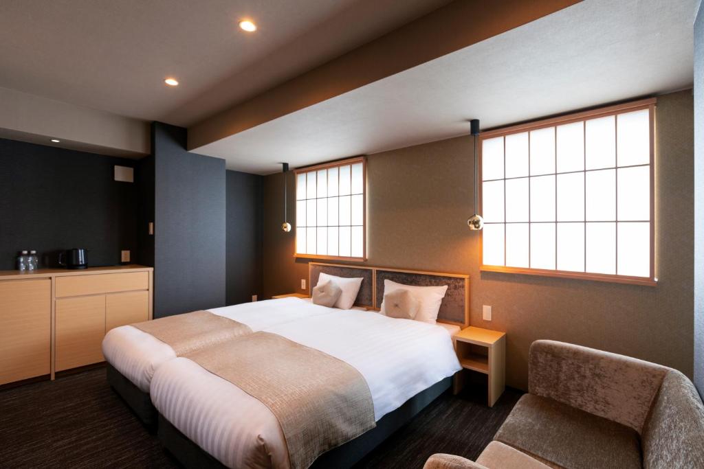 a bedroom with a large bed and two windows at Rinn Horikawa Gojo in Kyoto