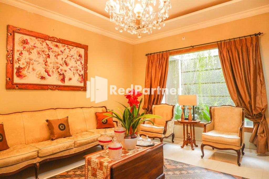 a living room with a couch and chairs and a chandelier at Rumah CIA Taman Siswa near Malioboro Yogyakarta Mitra RedDoorz in Timuran