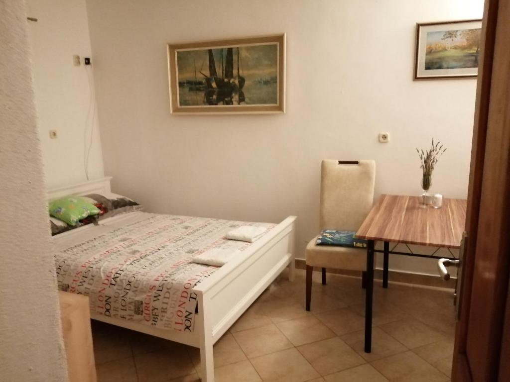 een kleine slaapkamer met een bed en een tafel bij Studio apartman Lina in Gradac