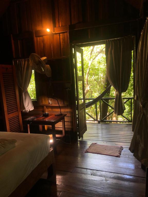 a room with a bed and a open door at Bambu Huts in Baan Tai