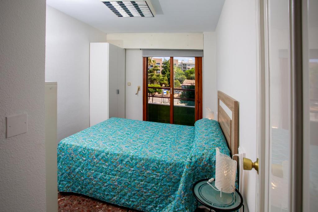 a bedroom with a blue bed and a window at GANDIACENTRUM in Gandía