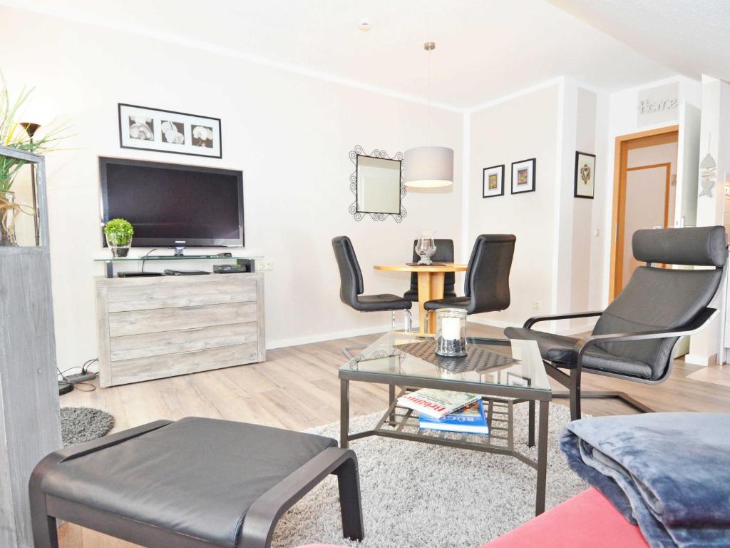 a living room with a tv and chairs and a table at Wohnpark Stadt Hamburg - Apt. 45 in Binz