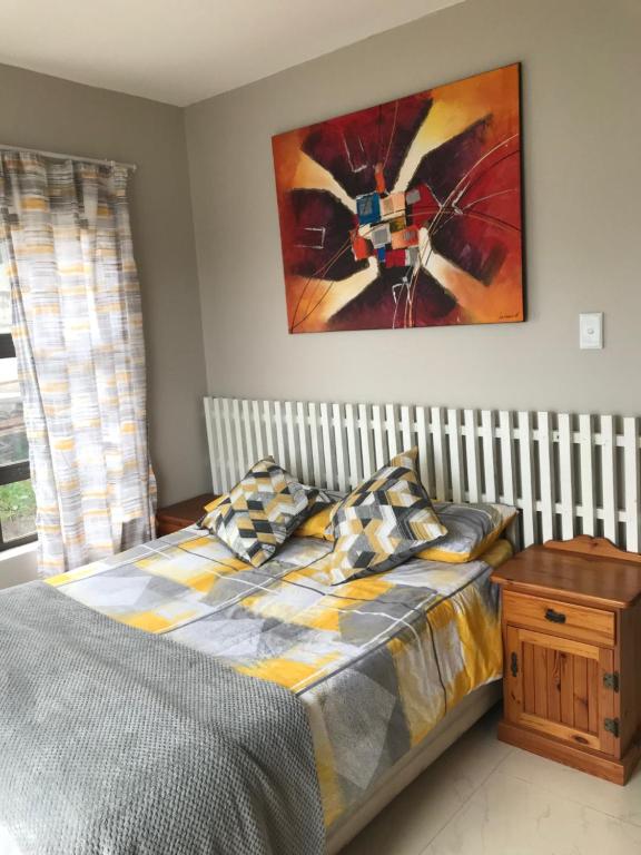 a bedroom with a bed and a painting on the wall at Margate Sunset Apartments in Margate