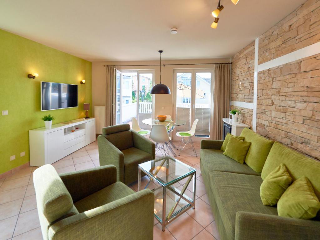 a living room with a green couch and chairs at Wohnpark Stadt Hamburg - Apt. 47 in Binz