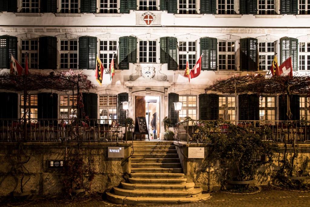 Herzogenbuchsee的住宿－黑措根布赫塞克魯澤酒店，前面有楼梯的建筑,有旗帜