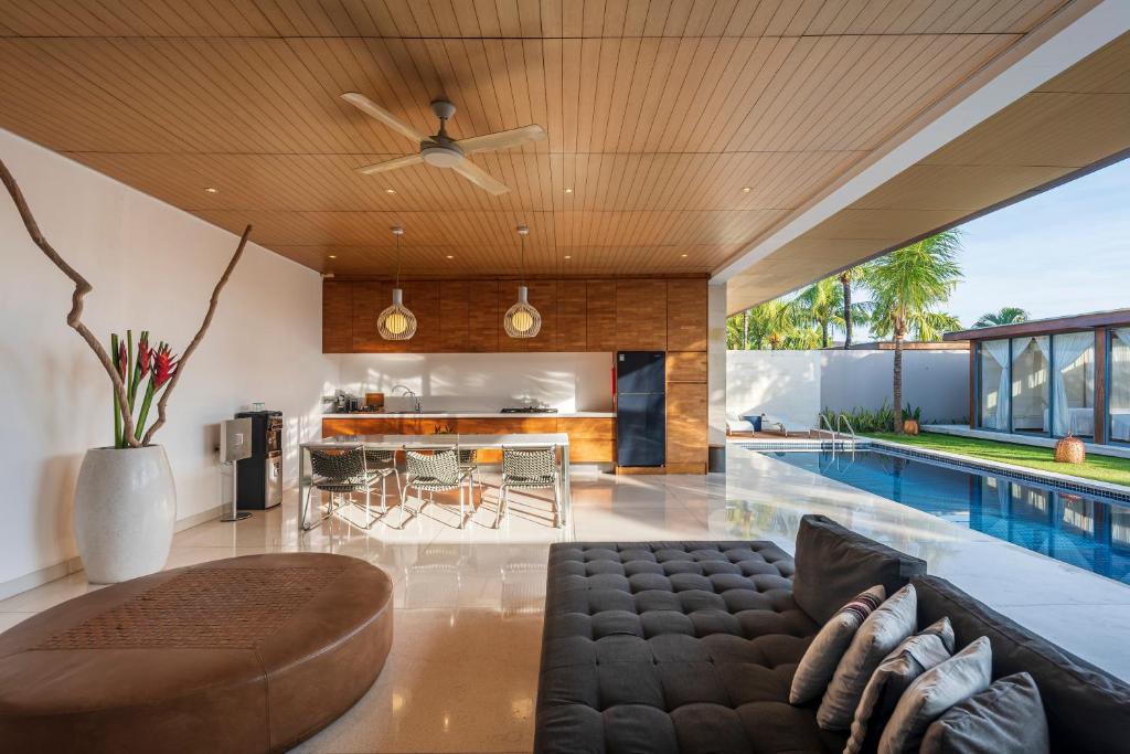 an open living room with a couch and a swimming pool at One Eleven in Seminyak