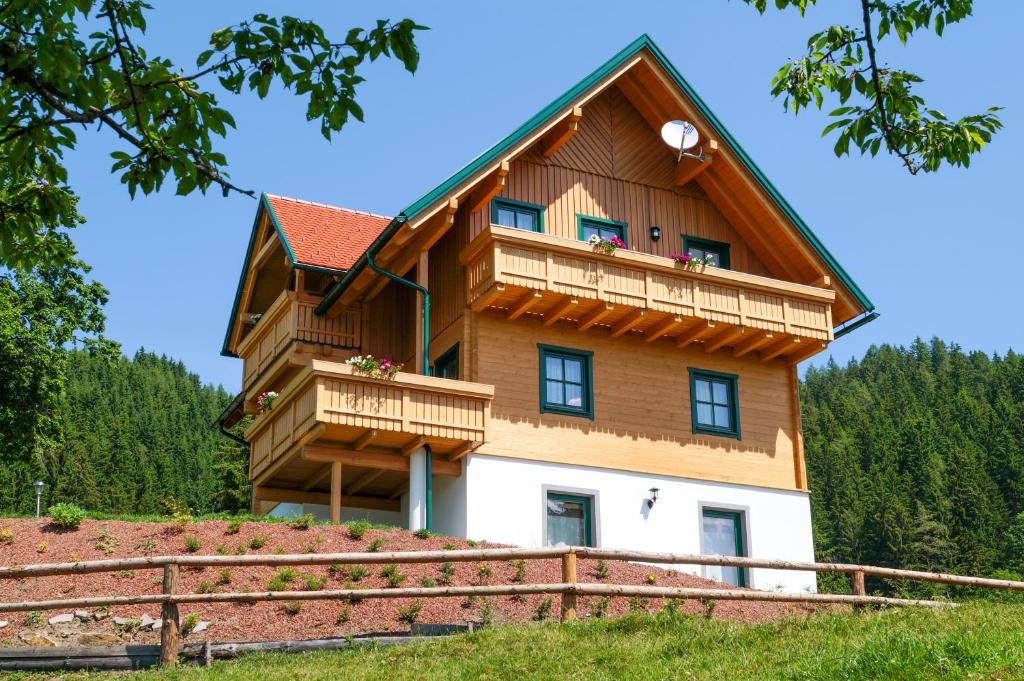a large wooden house with a balcony on a hill at Ferienhaus Hochfelner in Sankt Marein bei Knittelfeld